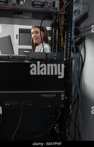Technicians using laptop while analyzing server in server room Stock Photo