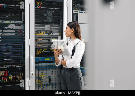 Technicians using laptop while analyzing server in server room Stock Photo