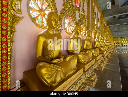 Row of golden Buddha statues in the corridor of the Phra Maha Chedi Chai Mongkhon Pagoda, Wat Pha Nam Yoi Temple Stock Photo