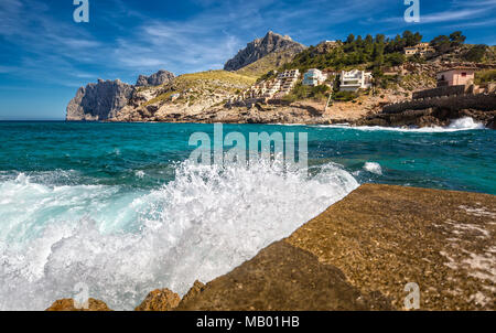 Splashing Water on the Pier of the Small Town Cala Sant Vincenc Stock Photo