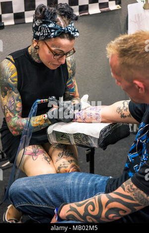 Cornwall Tattoo Convention - a tattooist tattooing a customers back at the Cornwall Tattoo Convention Stock Photo - Alamy