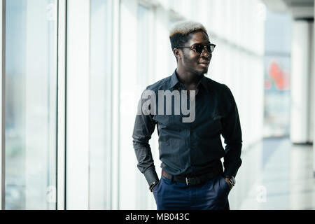 Rich business african man looking at panoramic window at his office. Stock Photo