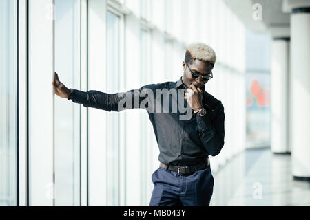 Rich business african man looking at panoramic window at his office. Stock Photo