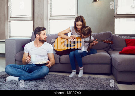 The family plays guitar together and sings songs.  Stock Photo