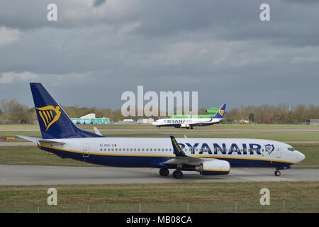 Ryanair aircraft taxiing in at London Stansted Airport as another Ryanair plane lands in the background Stock Photo