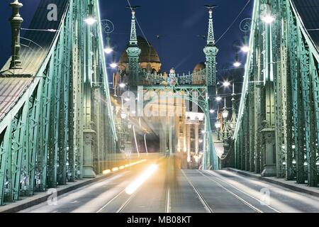 Budapest at night. Tram on old iron bridge - Szabadsag hid (Liberty bridge). Stock Photo