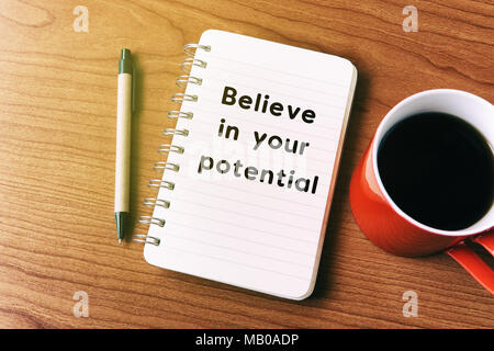 Inspirational quote on notepad - believe in your potential Stock Photo