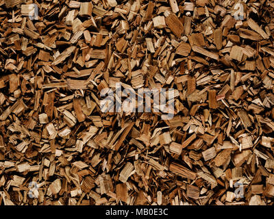 Dark brown wood chips create abstract rough-textured organic background surface Stock Photo
