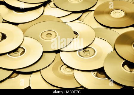 Random gold DVD and CD disks create data concept background Stock Photo