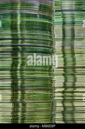 Stacks of green gold translucent DVD and CD computer storage disks create conceptual data technology background Stock Photo