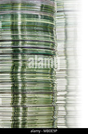 Stacks of monochrome metallic DVD and CD computer storage disks create conceptual data technology background with gradation Stock Photo