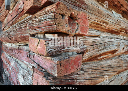 Close-up of a corner of an old log building in the western United States showing detail and grain in the fading painted wood. Stock Photo