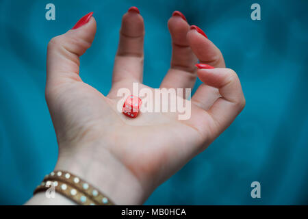 Red dice in woman’s hand at the blue backgroundrisk Stock Photo
