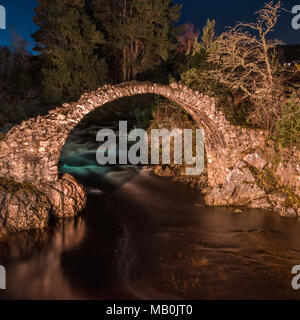 The old packhorse bridge built in 1717 over the River Dulnain in the village of Carrbridge near Aviemore in the Cairngorms Stock Photo