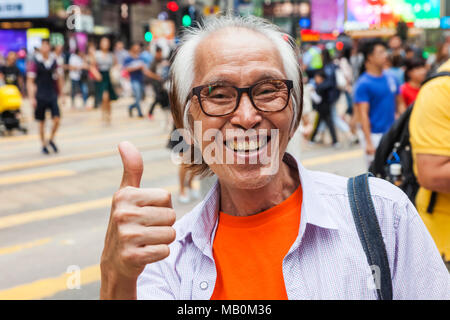 China, Hong Kong, Causeway Bay, Smiling Man Giving Thumbs Up Sign Stock Photo