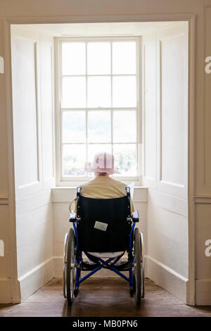England, Elderly Lady in Wheelchair Looking out of Window Stock Photo
