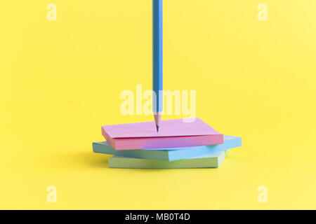 Sticky notes in different colors with pencil on yellow background minimal concept. Stock Photo