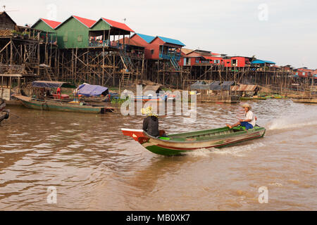 A local boat goes past in a stilt village, Kampong Khleang, Tonle Sap inland lake,  Cambodia, Asia Stock Photo