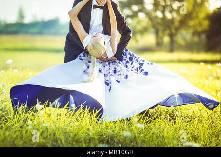 Just married couple running playing in a meadow Stock Photo