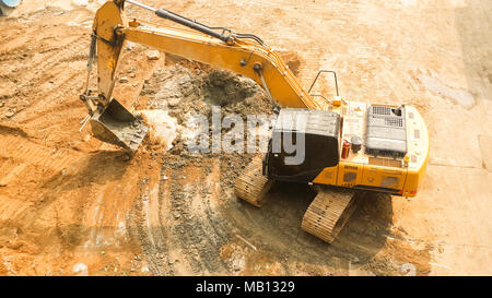 aerial view of Tracked excavator starts digging ground preparing to build condominium. track hoe working. Site preparation before building condominium Stock Photo