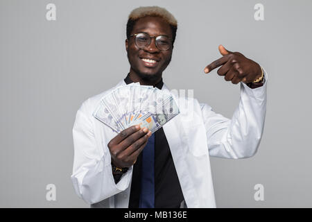 Serious African surgeon in uniform holding money - Isolated Stock Photo