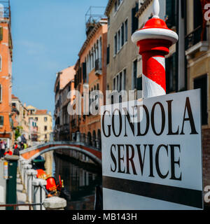 Selective focus on traditional red and white poles advertising Gondola Services in Venice. Stock Photo