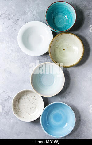 Empty colorful ceramic bowls collection. Various of dishware grey texture background. Top view Stock Photo