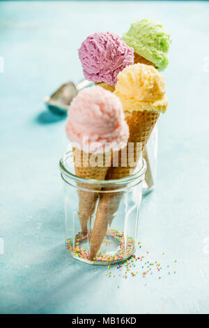 Various of ice cream flavor in cones pink (strawberry, raspberry), purple (blueberry), green (pistachio, green tea, lime) and yellow (mango, banana) s Stock Photo