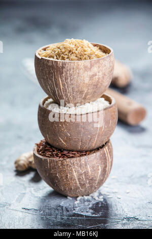 Assortment of different rice in bowls: Rice berry, Brown rice and Risotto rice on grey stone background. Stock Photo