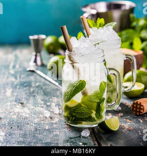 Mojito cocktail with lime and mint in glass jars on the table. Copy space Stock Photo