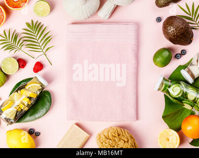 Detox fruit infused water, tropical fruits, leaves and SPA settings on pink pastel background. Top view, flat lay, space for text Stock Photo