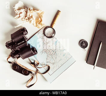 Making a travel plan. Tourist devices on white paper background. Vintage toned image. Top view. Flat lay.