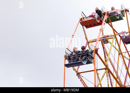 Children looking down and screaming on a fairground ferris wheel. Stock Photo