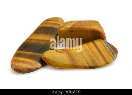 Close-up of three tiger eye gemstones on white background Stock Photo