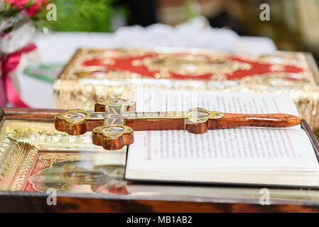 The decorated wooden Cross, the prayer book, the icon and the Bible on the altar in the Christian temple Stock Photo