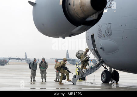 U.S. Army Paratroopers assigned to Headquarters and Headquarters Battalion, 82nd Airborne Division, board an Air Force C-17 Globemaster III aircraft on Pope Army Airfield at Fort Bragg, N.C., Feb. 10, 2018, after loading their vehicles and systems as part of Operation Falcon Storm. OFS, a deployment readiness and joint forcible entry exercise, tested the Paratroopers ability to respond and fight within hours of notification. Stock Photo