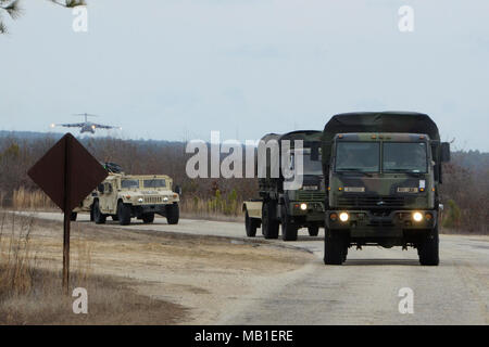 Paratroopers assigned to Headquarters and Headquarters Battalion, 82nd Airborne Division, convoy away from Pope Army Airfield on Fort Bragg, N.C., Feb. 10, 2018, after their vehicles and systems came off a C-17 Globemaster III aircraft during Operation Falcon Storm. OFS, a deployment readiness and joint forcible entry exercise, tested the Paratroopers ability to respond and fight within hours of notification. Stock Photo