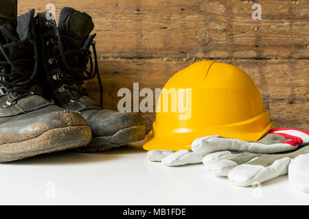 Equipment safety standard. Yellow hard hat, construction boots and gloves. Stock Photo