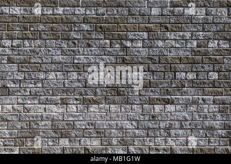 Brick wall made of grey and dirty white bricks. Full size front view. Stock Photo