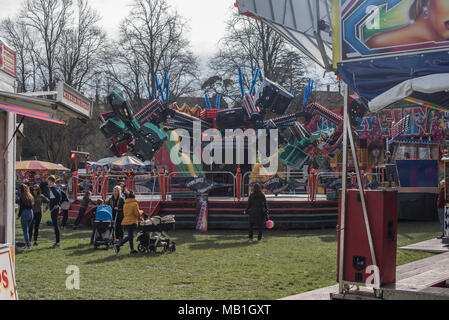People enjoying the fairground rides at the fun fair on a bright and sunny spring day afternoon in Shrewsbury in Shropshire, the west midlands Stock Photo