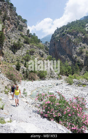 Couple walking out of southern entrance to the Samaria Gorge. Agia Roumeli, Sfakia, Chania Region, Crete (Kriti), Greece Stock Photo