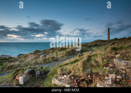 tin mines and engine houses on the cornish coast on penwith at botallck and levant in the evening light and the cliff tops stormy sky. industrial. Stock Photo