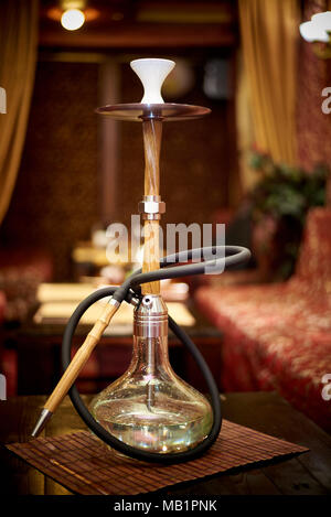 A glass hookah is on the table in the lounge bar Stock Photo