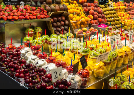 Variety of fresh fruit in plastic containers, ready for sale, in the market of La Boqueria Stock Photo