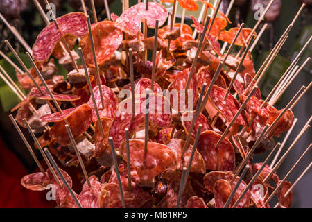 Slices of salami inserted in chopsticks exposed for tasting Stock Photo