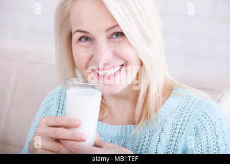 Happy middle aged woman drinking milk Stock Photo
