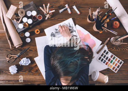 top view of female artist sleeping on sketches at workplace  Stock Photo