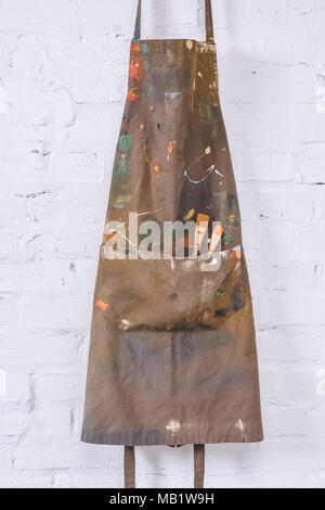 artist apron with paint brushes hanging on brick wall Stock Photo - Alamy