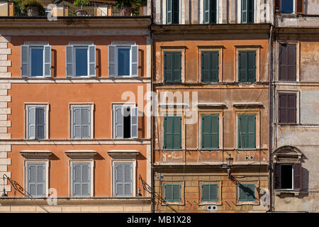 Windows and shutters on the weathered facade of buildings in Rome, Italy on a bright sunny day in August. Stock Photo
