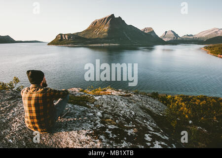 Man sitting alone enjoying sea and mountains view Travel lifestyle adventure outdoor summer vacations wild nature Stock Photo